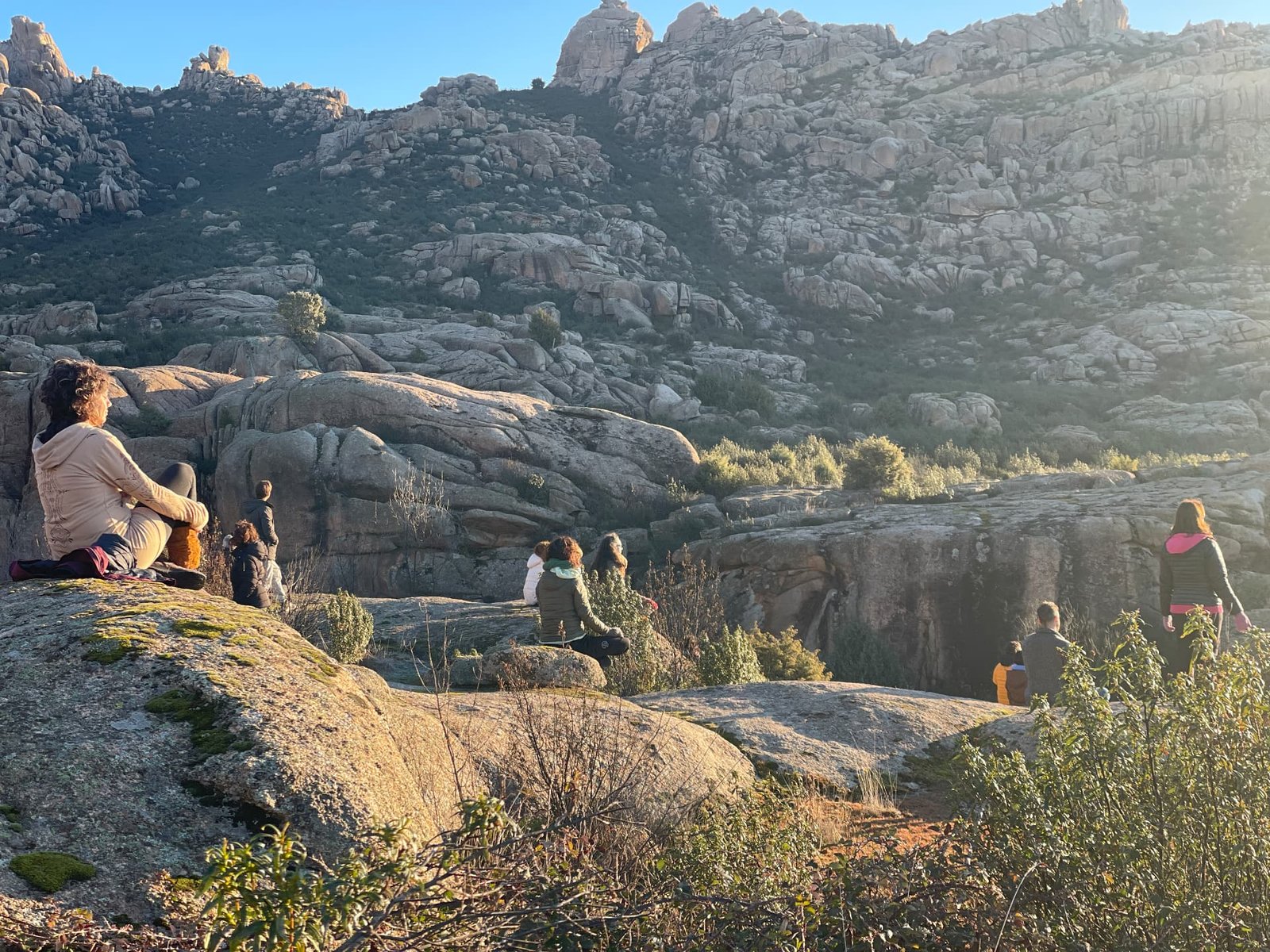 Grupo sentado en las rocas de La Pedriza al amanecer